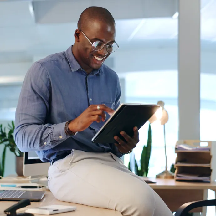 A happy business owner reviewing his brand new site on a tablet